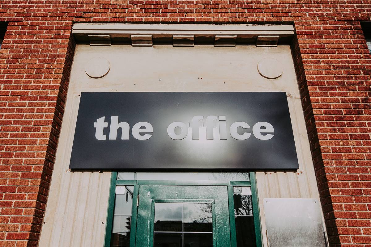 Black and white office sign on brick wall
